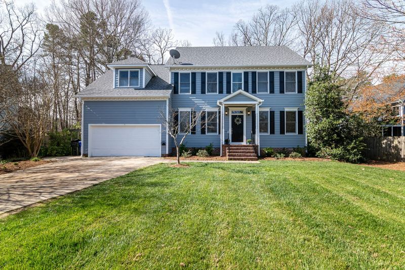 A freshly mowed front lawn outside a tidy suburban home